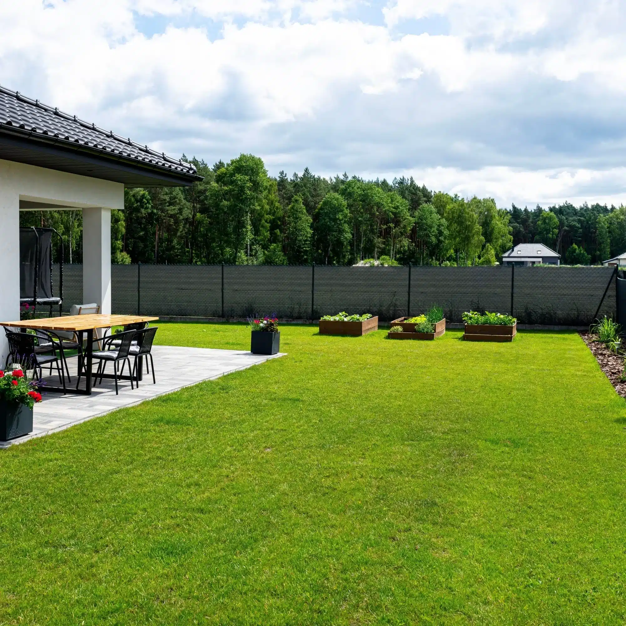 Rénovation façade maison : échafaudage et chantier Chantier de rénovation extérieure d'une maison moderne, échafaudages métalliques devant les façades couleur crème sous un ciel bleu avec nuages.